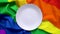 White plate on the background of a rainbow LGBT symbol close - up for design. Lunch dish on a rainbow background.