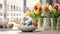 White plate with colored easter eggs, bouquet of multicolored tulips flowers in vase on white kitchen table near window. Festive