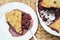 white plate with fresh berry pie, crumble or cobbler with cranberry and raspberry. warmin hearty food, comforting meal.