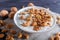 White plate with greek yogurt, granola, almond, cashew, walnuts  on black wooden background