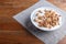 White plate with greek yogurt, granola, almond, cashew, walnuts  on brown wooden background