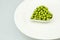 The white plate, a heart-shaped small, fresh peas