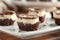 A white plate holds a tempting display of brownies topped with rich, creamy frosting. The delicious treats invite