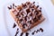 White plate with homemade belgian waffles with Sifting sugar powder over black background.