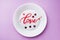 White plate inscription love on a pink background. Concept Valentine`s day