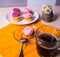 White plate with muffins, cakes, coffee mug and a bouquet of wildflowers