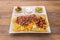 White plate of nachos with guacamole neatly ordered