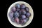White plate with plums