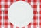 White plate on red and white checkered cloth