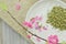 White plate with rice tea and peach flower blooming, detail