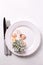 White plate, shells, cutlery, coral, succulent echeveria on whit