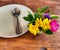 A white plate with a spoon and fork, top view, old wooden tableware  With beautiful flower arrangements  Restaurant concept