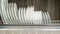 White plates on a metal drying rack.