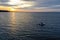 White pleasure boat against the setting sun on the Gulf of Finland on a summer day. Powerboat. Evening. Reflection of sun glare in