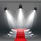 White podium and red carpet illuminated by spotlights