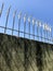 White pointed iron fence, concrete wall, sunshine