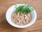 White porcelain bowl with shredded tuna in oil for salad and green dill on a wooden background. Seafood, healthy eating and cook