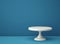 White porcelain cake stand on blue backgroung