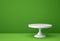 White porcelain cake stand on green backgroung