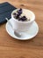 White porcelain cup of black coffee with flowers of violet