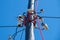 White porcelain insulators on the post against the blue sky