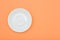 White porcelain saucer on peach color background