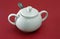 White porcelain sugar bowl with lid and spoon.