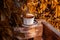 White porcelain tea cup on the wooden balcony yellow wild grapes background. Warm healthy herbal drink.Weekend breakfast