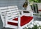 White porch swing with red cushions