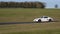 A white Porsche sportscar speeding round corners