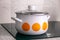 White pot with yellow circles on induction hob