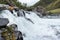 White powerful blurred waterfall high exposure macro with water drops and beautiful mountains background