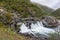 White powerful waterfall macro with water drops and beautiful mountains background