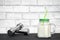 White protein cocktail in a mug on the background of dumbbells and a white wall decorated with bricks. Background