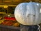 White Pumpkin on Wooden Post in front of a Fresh Produce Farm Store