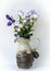 White and purple lisianthus flowers in clay vase