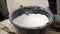 White putty cement in black bucket on floor for rebuild wall at home - can use to display or montage on product. White mixture in