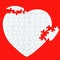 A white puzzle heart on a red background of parts, ununited, damaged, incomplete, but the parts are all there