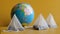 White pyramid tea bags with black tea flavored with fruits and berries lie next to a globe on a yellow background. The concept of