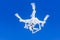 White quadcopter in clear blue skies