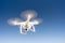 White Quadcopter Drone Flying Hoovering Blue Sky