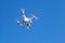 White quadrocopter in blue sky