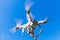 White quadrocopter flying in blue sky, spy drone