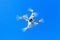 White quadrocopter in sky, under wireless control