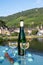 White quality riesling wine served on old bridge across Mosel river with view on old German town in sunny day