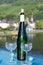 White quality riesling wine served on old bridge across Mosel river with view on old German town in sunny day