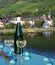 White quality riesling wine served on old bridge across Mosel river with view on old German town in sunny day