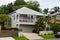 White queenslander home with tropical greenery and tall trees on overcast day in Australia