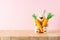 White rabbit doll with carrots on on wooden table. Minimal Easter background. Spring holidays concept