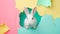 White rabbit peeking through torn pastel colored paper background. Easter poster concept